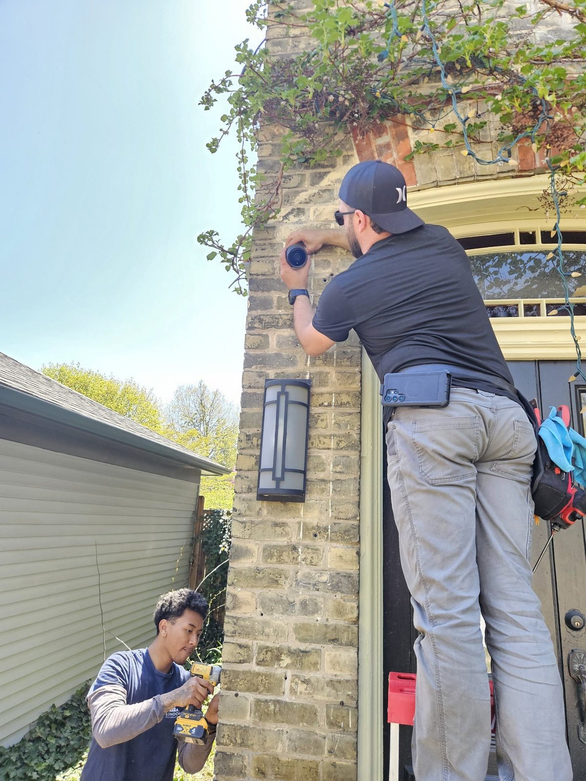 London Tech Solutions team installing a UniFi G6 bullet camera on a 100-year-old brick home in Wortley Village, London Ontario