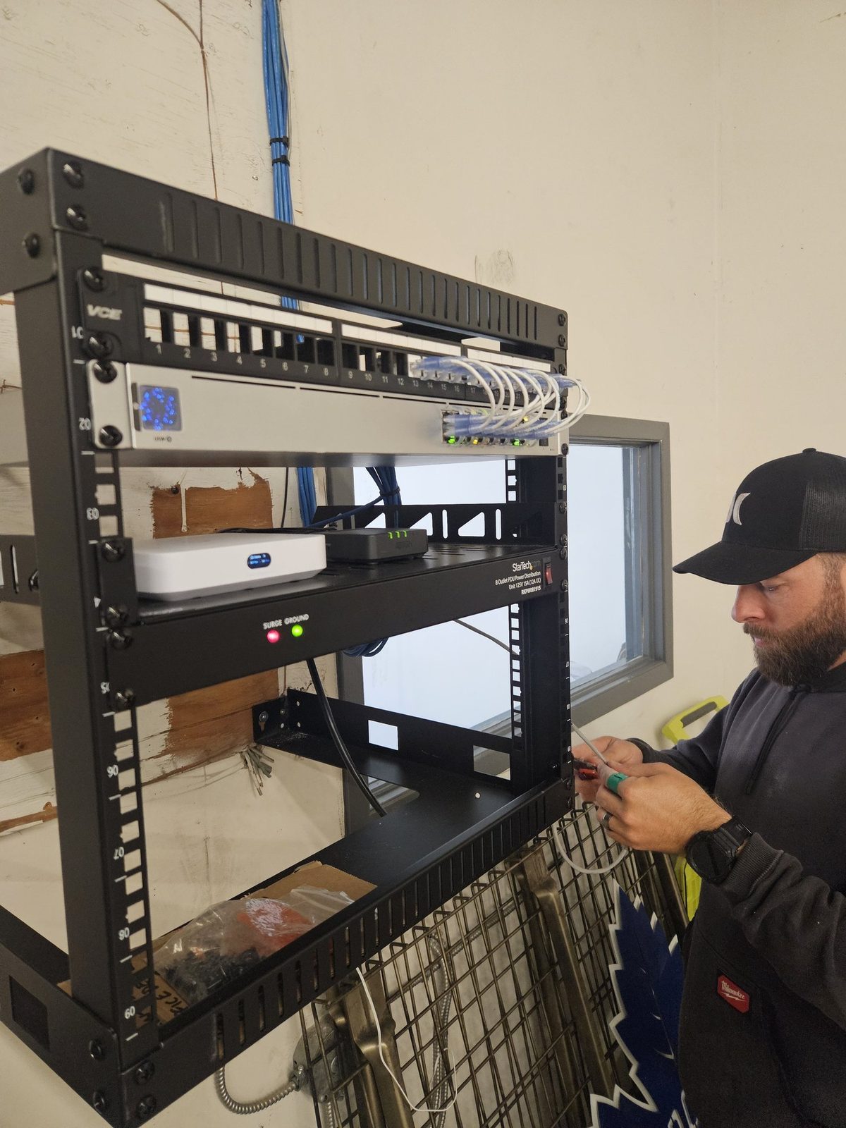 Wall-mounted network rack with keystone patch panel and UniFi PoE switch installed by London Tech Solutions in South London Ontario
