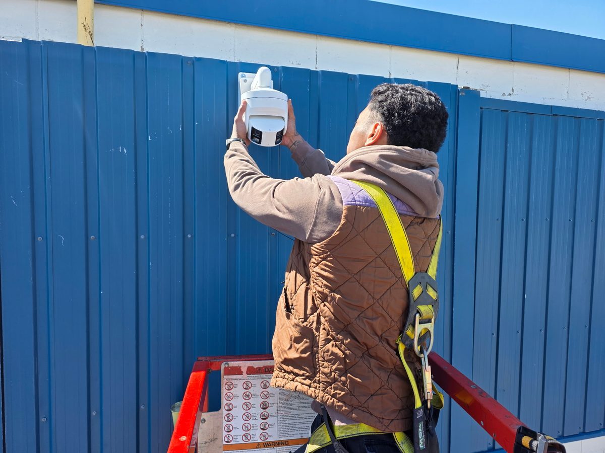 London Tech Solutions technician mounting a Hikvision panoramic camera high on a building wall