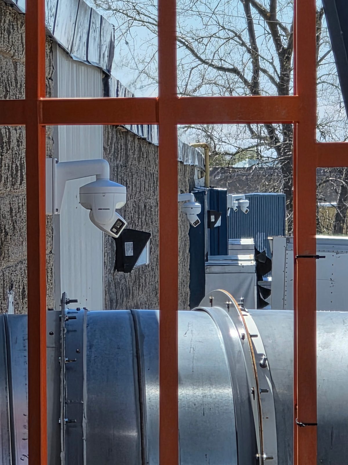 Several Hikvision panoramic active-deterrence cameras positioned along the facility perimeter