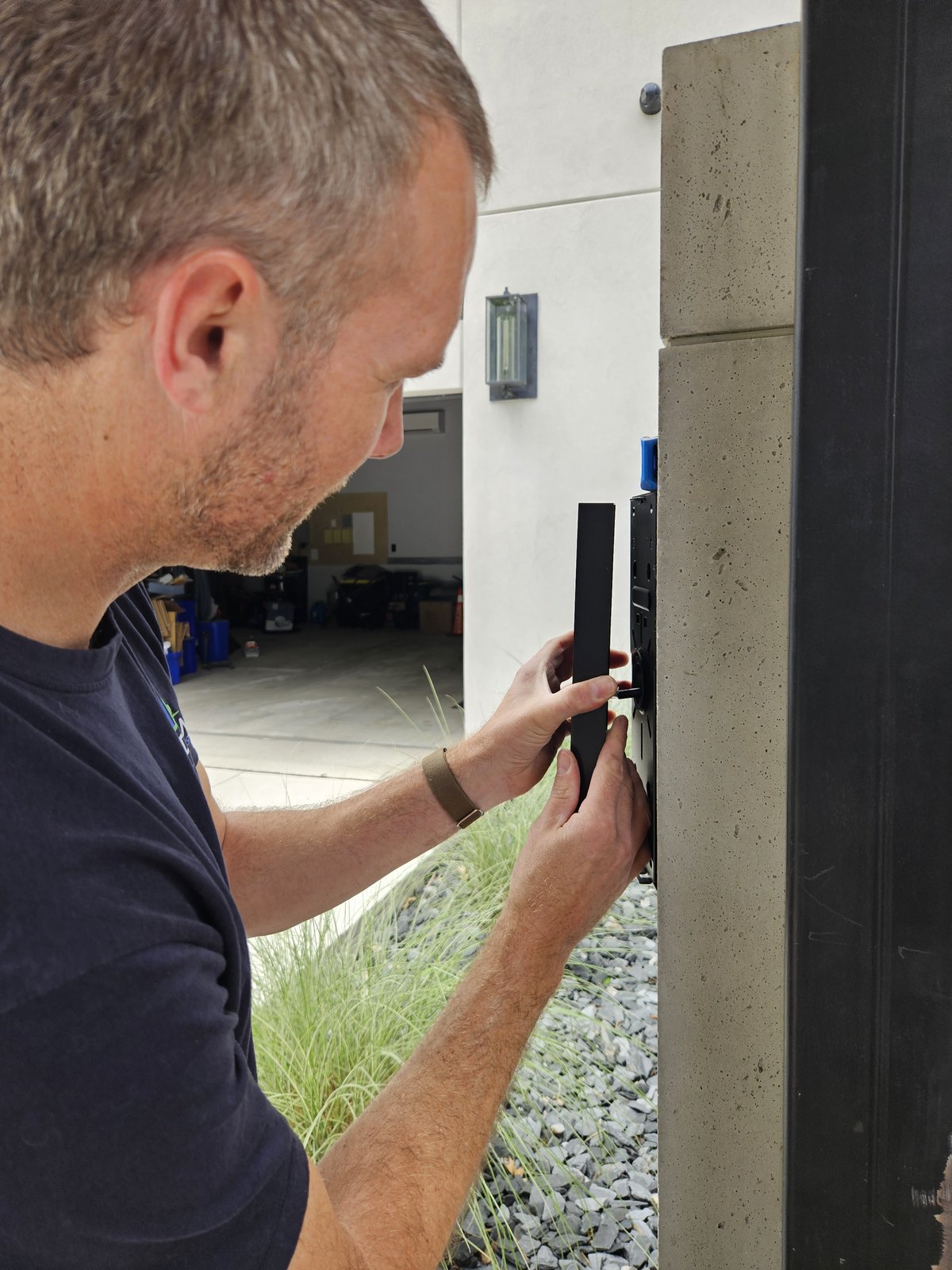 London Tech Solutions technician setting a UniFi G3 Intercom level into a custom concrete gate pillar