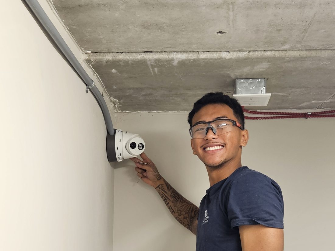 Marcus, installation technician at London Tech Solutions, installing a security camera