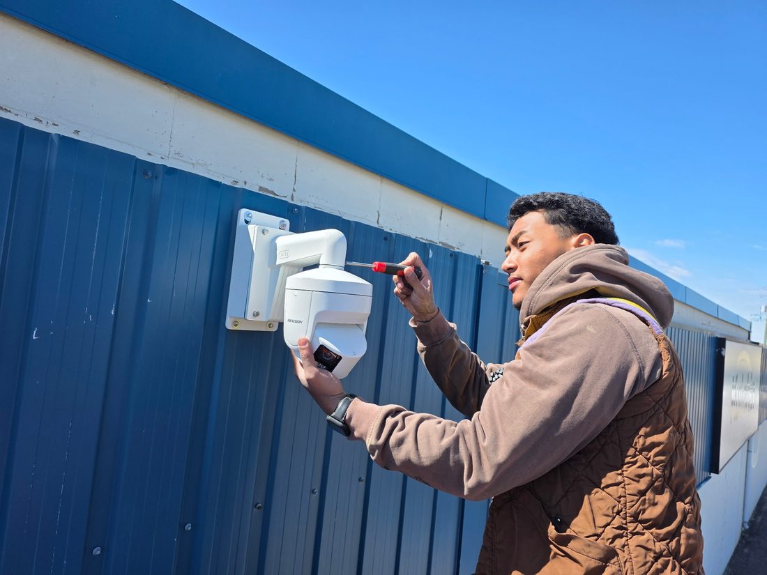 London Tech Solutions technician installing a commercial security camera on a building exterior
